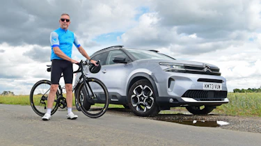 Auto Express senior photographer Pete Gibson standing with a bicycle next to the Citroen C5 Aircross