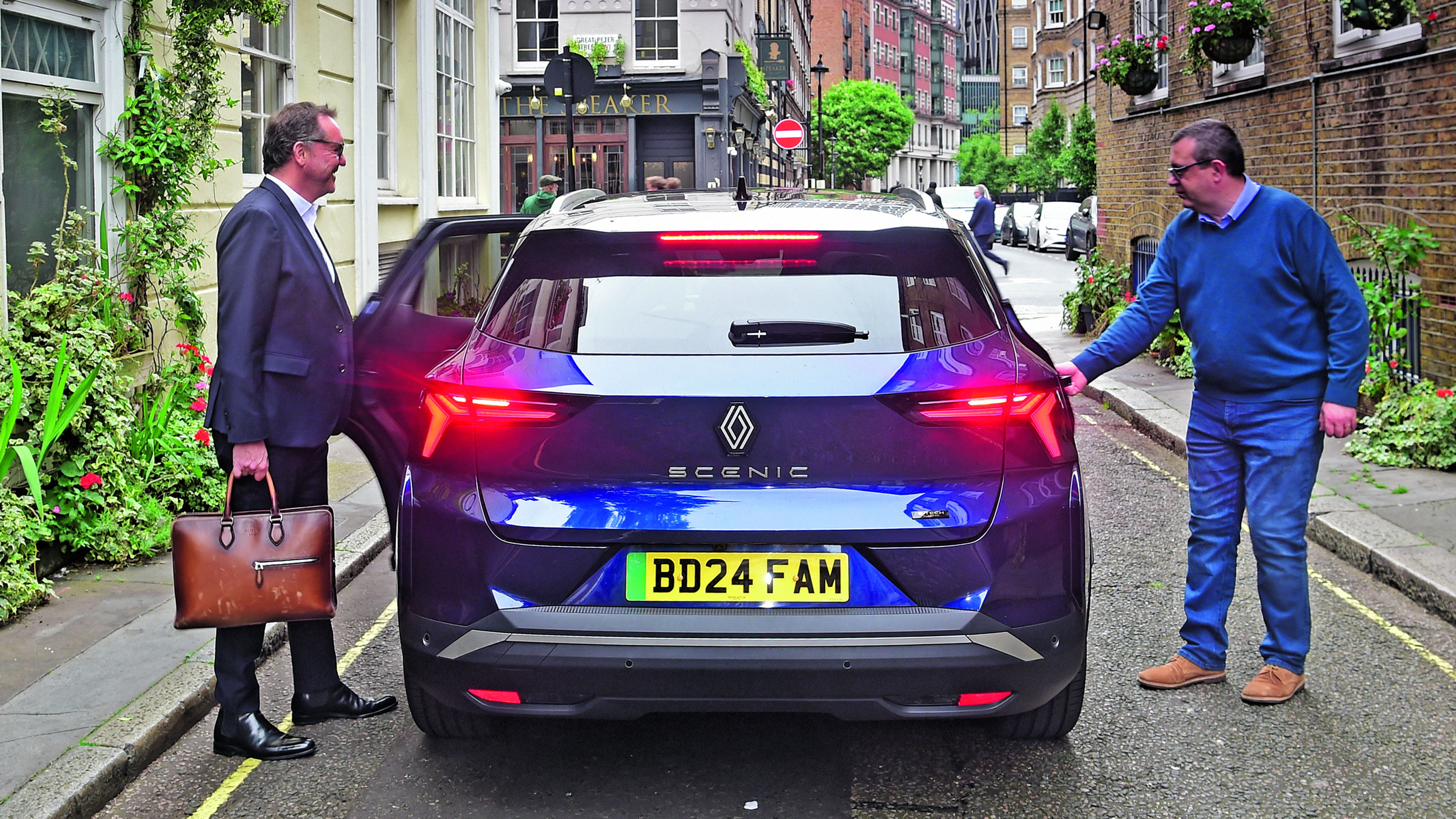 Out-going Renault UK boss Guillaume Sicard and John McIlroy getting into the back of a Renault Scenic