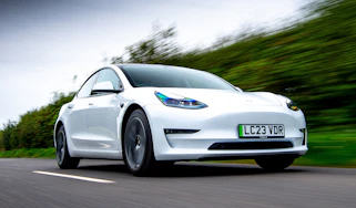 Tesla Model 3 driving down the road
