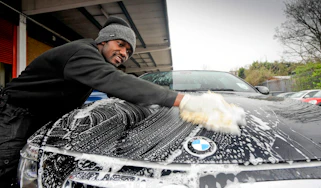 Man cleaning a BMW