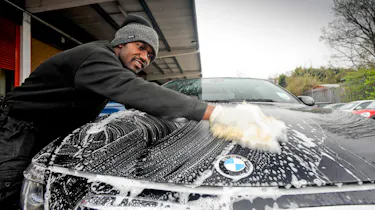 Man cleaning a BMW