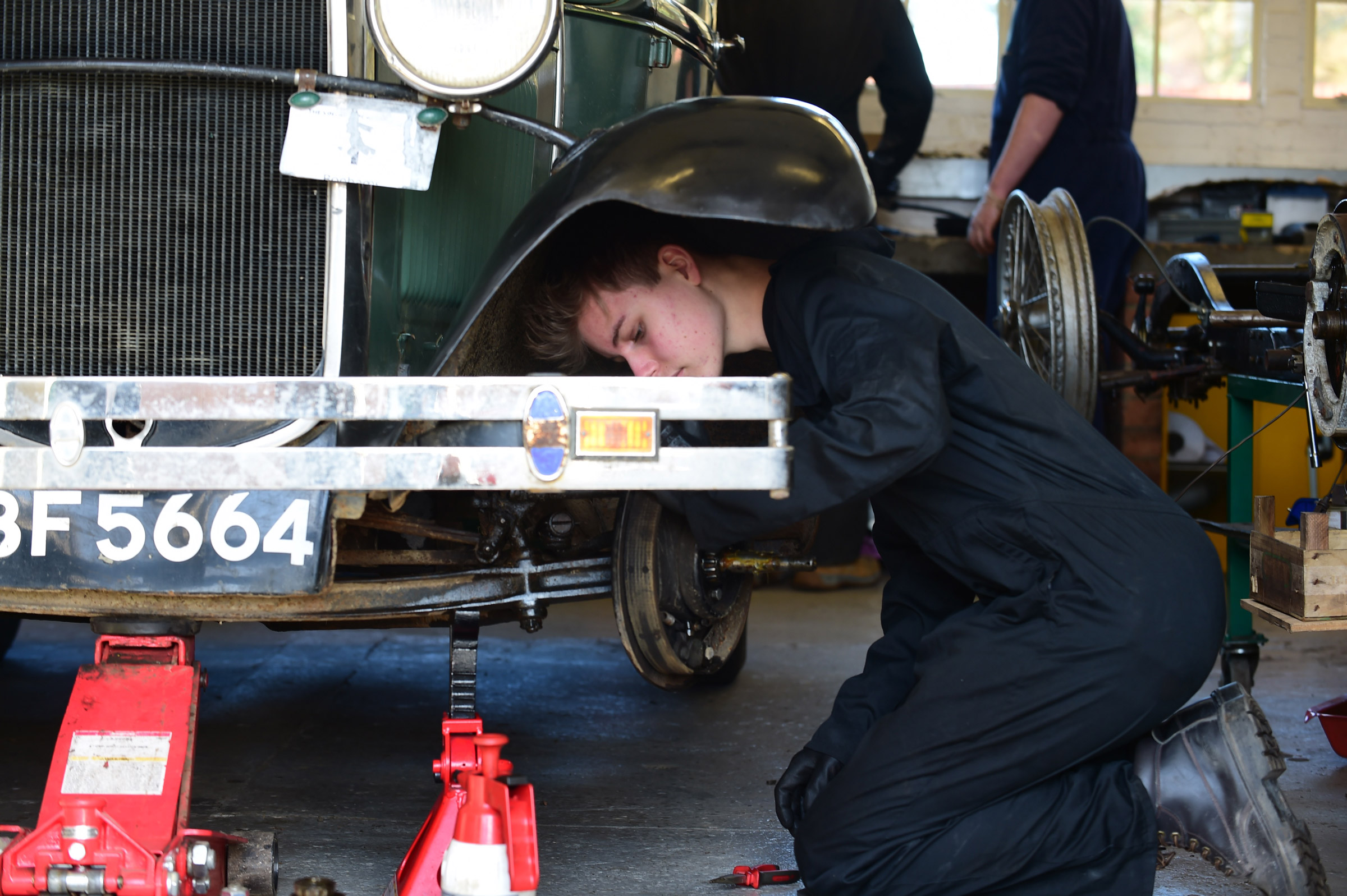 Student mechanic inspecting classic car