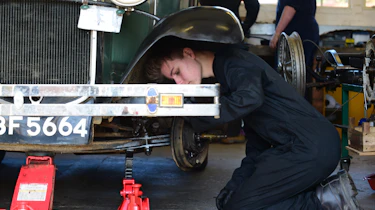 Student mechanic inspecting classic car