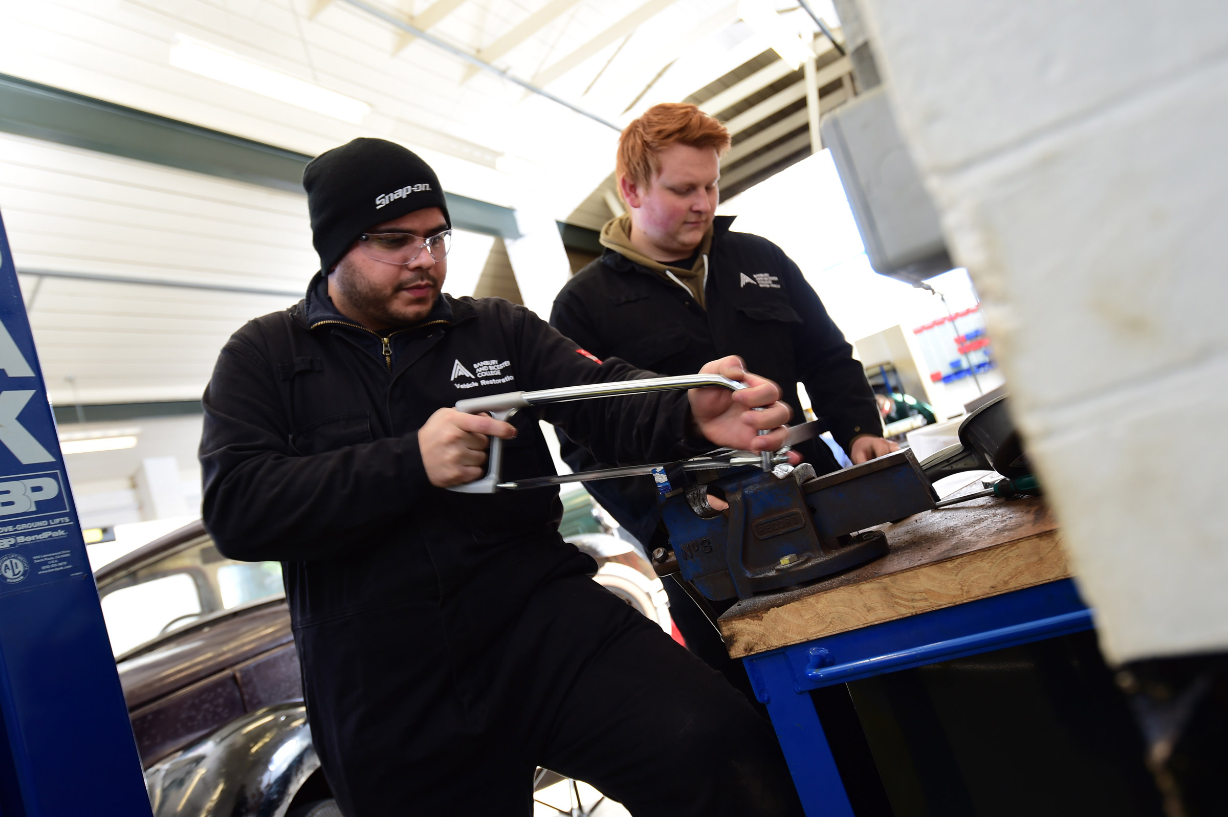 Student mechanics working on classic car