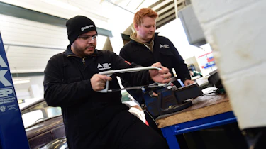 Student mechanics working on classic car