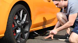 Person using a scissor jack to lift a car