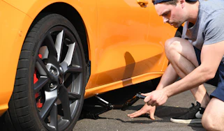 Person using a scissor jack to lift a car