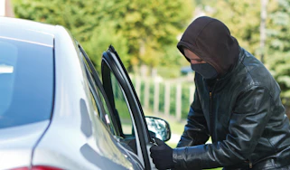 Thief breaking into car