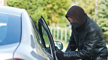 Thief breaking into car
