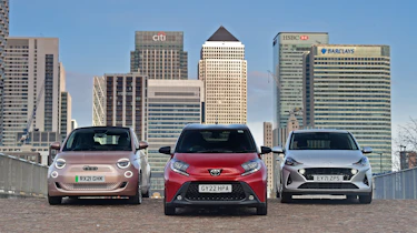 Toyota Aygo X vs Hyundai i10 vs Fiat 500 group test - three cars in front of London city skyline