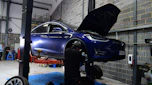 Tesla Model X on two-post inspection ramp
