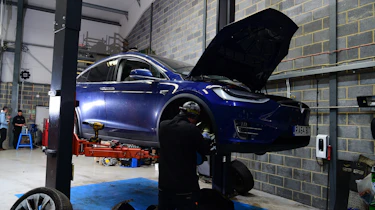 Tesla Model X on two-post inspection ramp