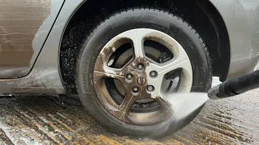 Alloy wheel being cleaned with pressure washer