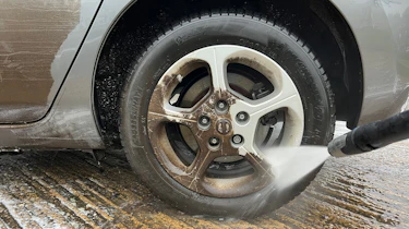 Alloy wheel being cleaned with pressure washer