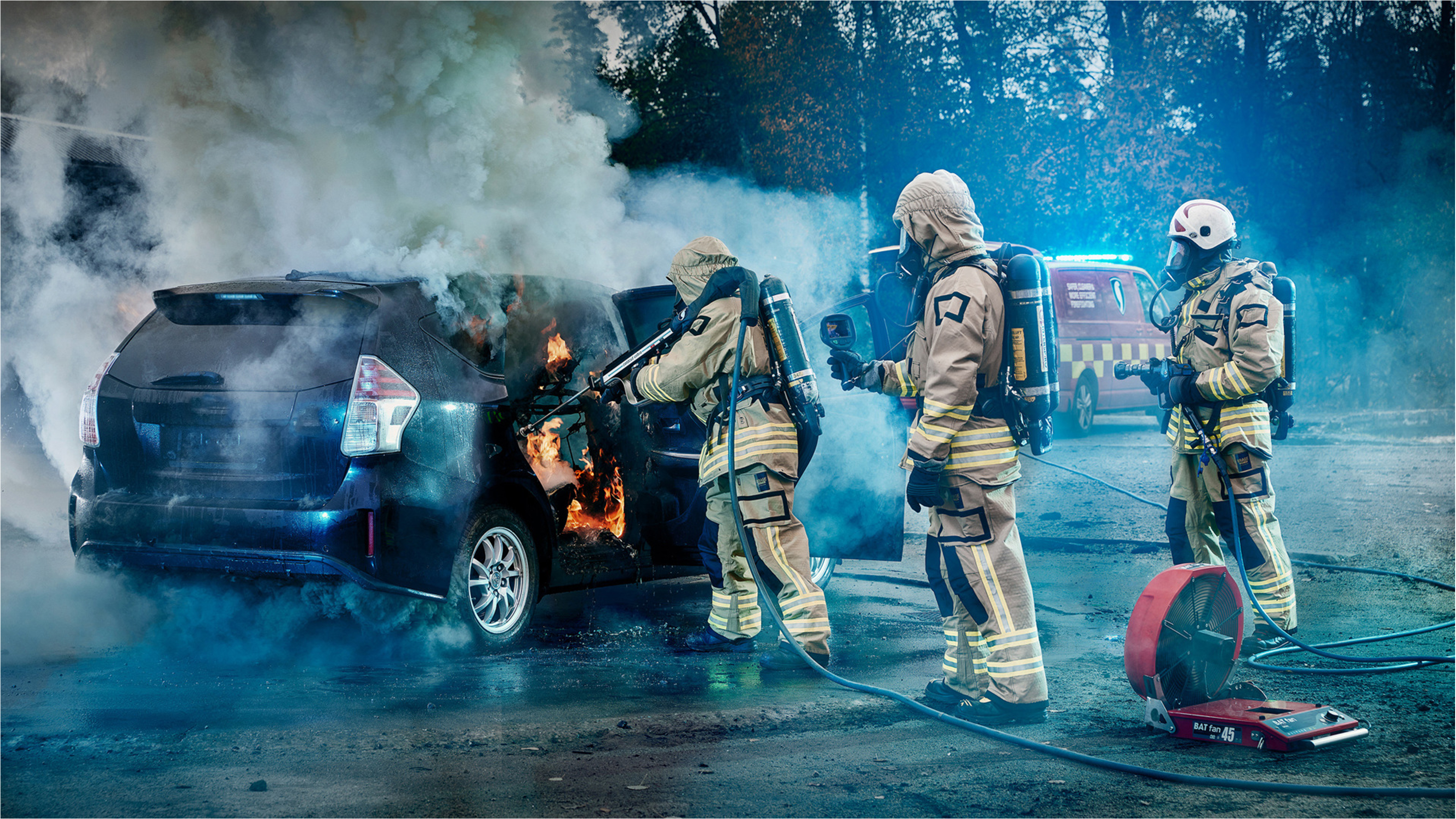 Firefighters extinguishing fire in Toyota Prius+