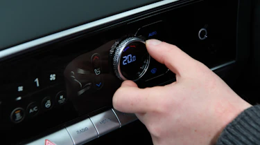 Auto Express chief reviewer Alex Ingram operating Genesis Electrified GV70's climate controls