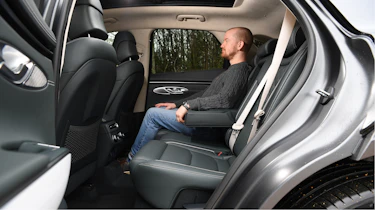 Auto Express chief reviewer Alex Ingram sitting in Genesis Electrified GV70's rear seat