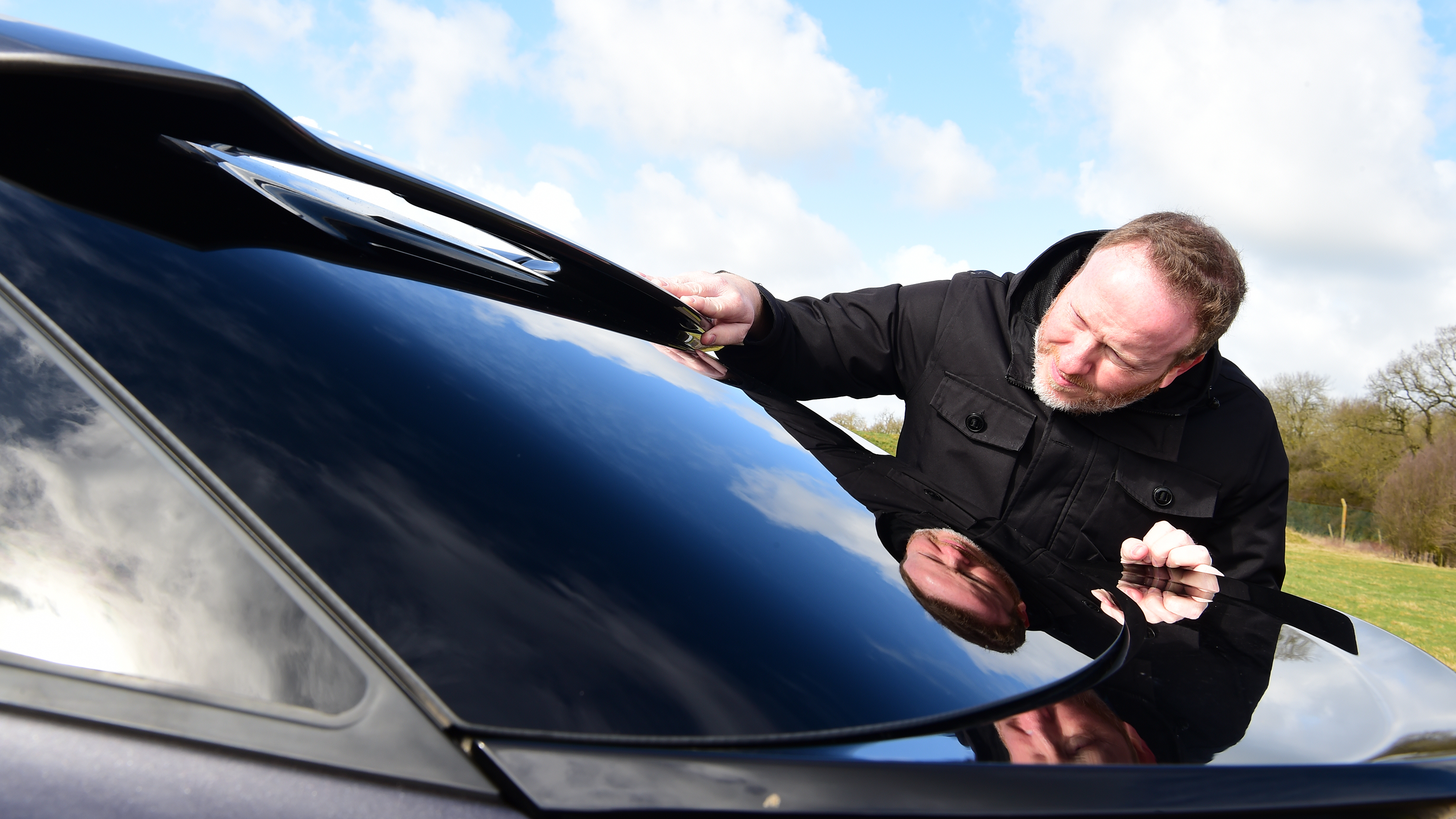 Auto Express Web Producer Pete Baiden inspecting Citroen C5 X rear window