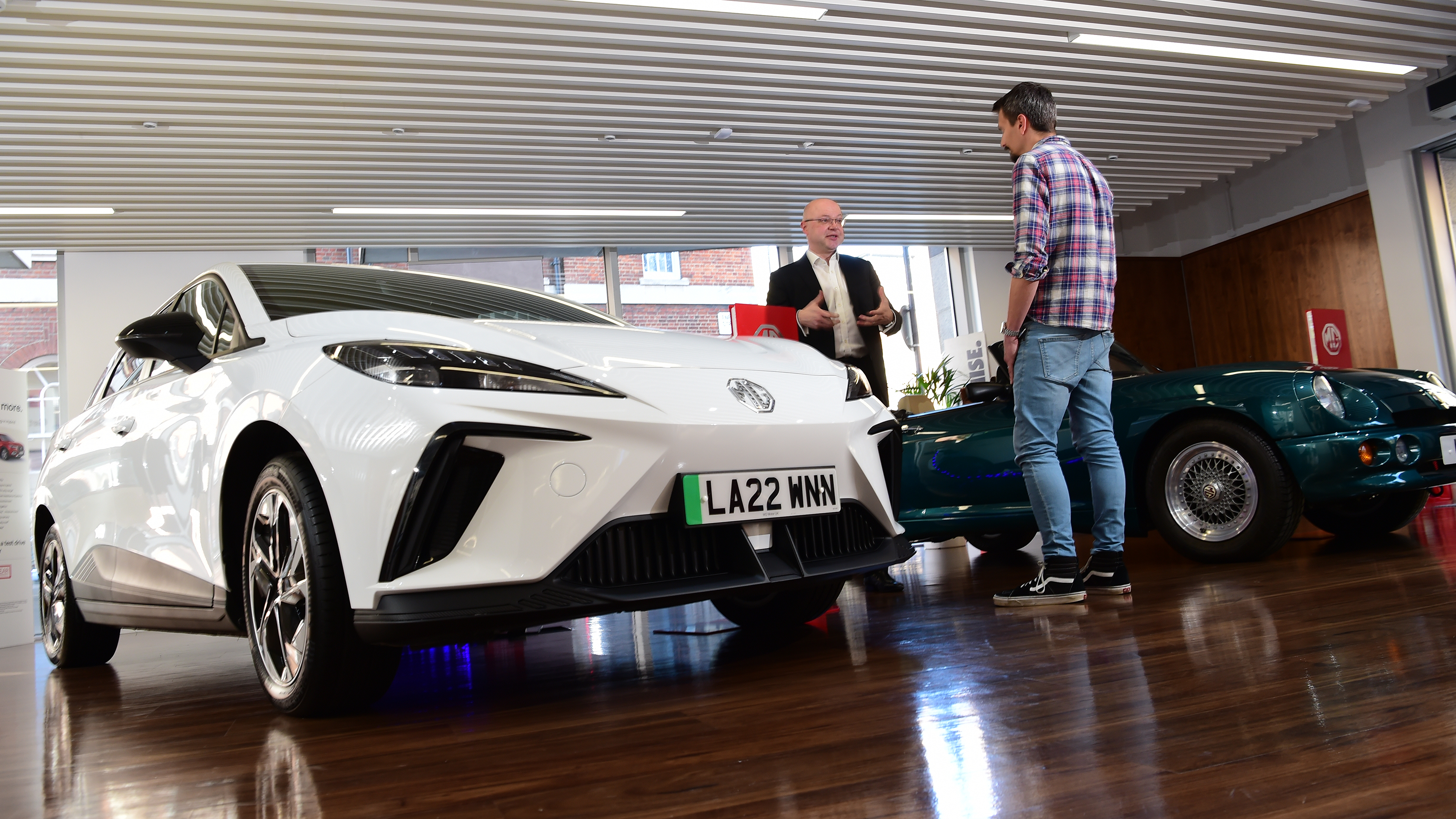 Auto Express deputy executive editor Matt Robinson talking to MG Motor UK head of product and planning systems David Allison with MG4 in foreground