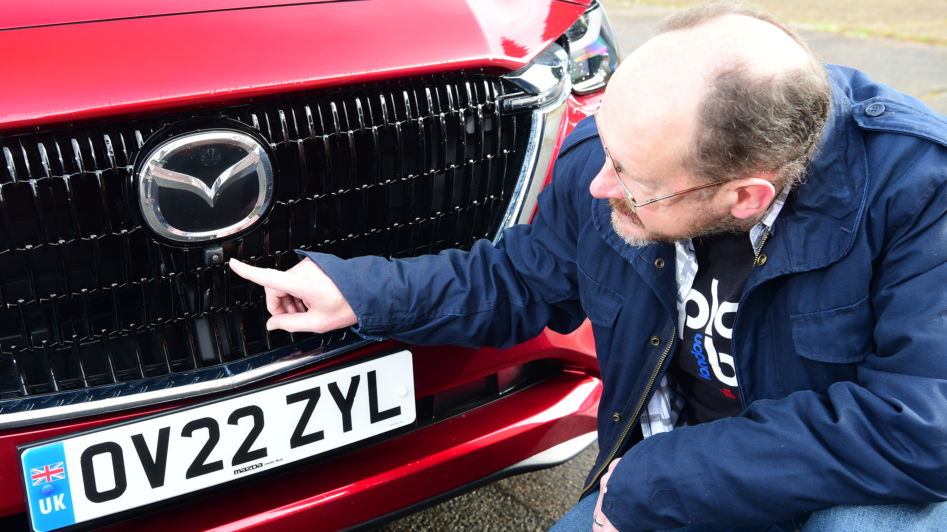Auto Express chief sub-editor Andy Pringle pointing at Mazda CX-60 front camera