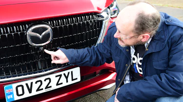 Auto Express chief sub-editor Andy Pringle pointing at Mazda CX-60 front camera