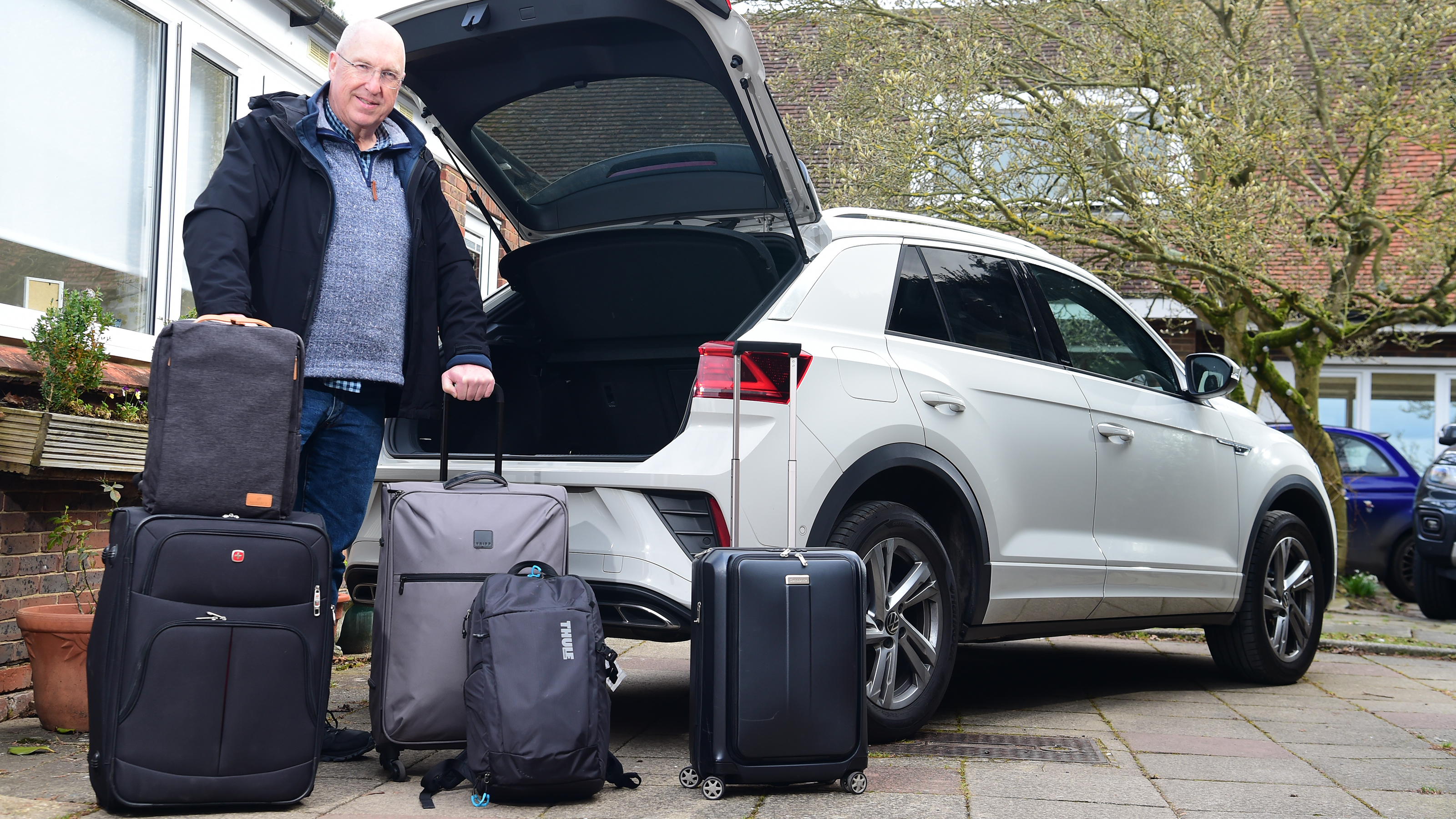 Kim Adams standing with luggage behind Volkswagen T-Roc