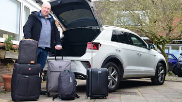 Kim Adams standing with luggage behind Volkswagen T-Roc