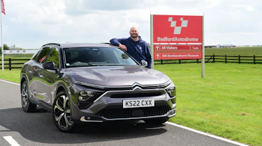 Autovia group automotive art director Darren Wilson standing next to Citroen C5 X outside Bedford Autodrome