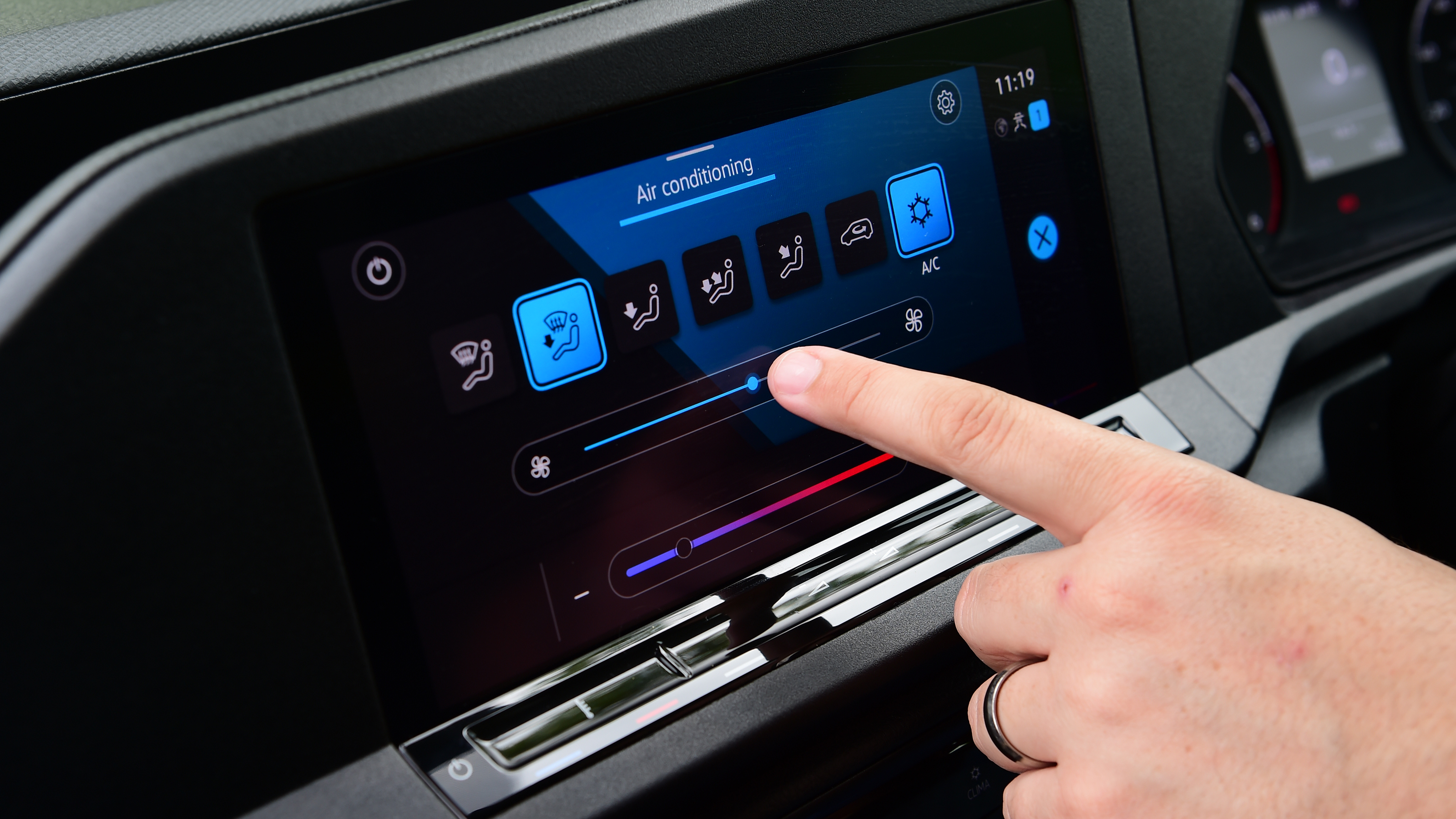 Auto Express senior test editor Dean Gibson standing between operating the Volkswagen Caddy's infotainment system