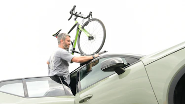 Driving Electric & Carbuyer editor Richard Ingram attaching a bike to the roof-rack of the Volvo XC40