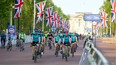 Driving Electric & Carbuyer editor Richard Ingram cycling down Pall Mall as part of racing event