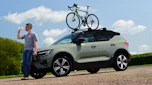 Driving Electric & Carbuyer editor Richard Ingram drinking next to the Volvo XC40