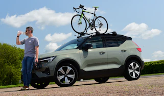 Driving Electric & Carbuyer editor Richard Ingram drinking next to the Volvo XC40