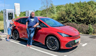 Auto express deputy editor John McIlroy standing with the Cupra Born while it charges