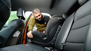 Carbuyer and DrivingElectric editor Richard Ingram fitting a child's car seat to the MG4's back seat