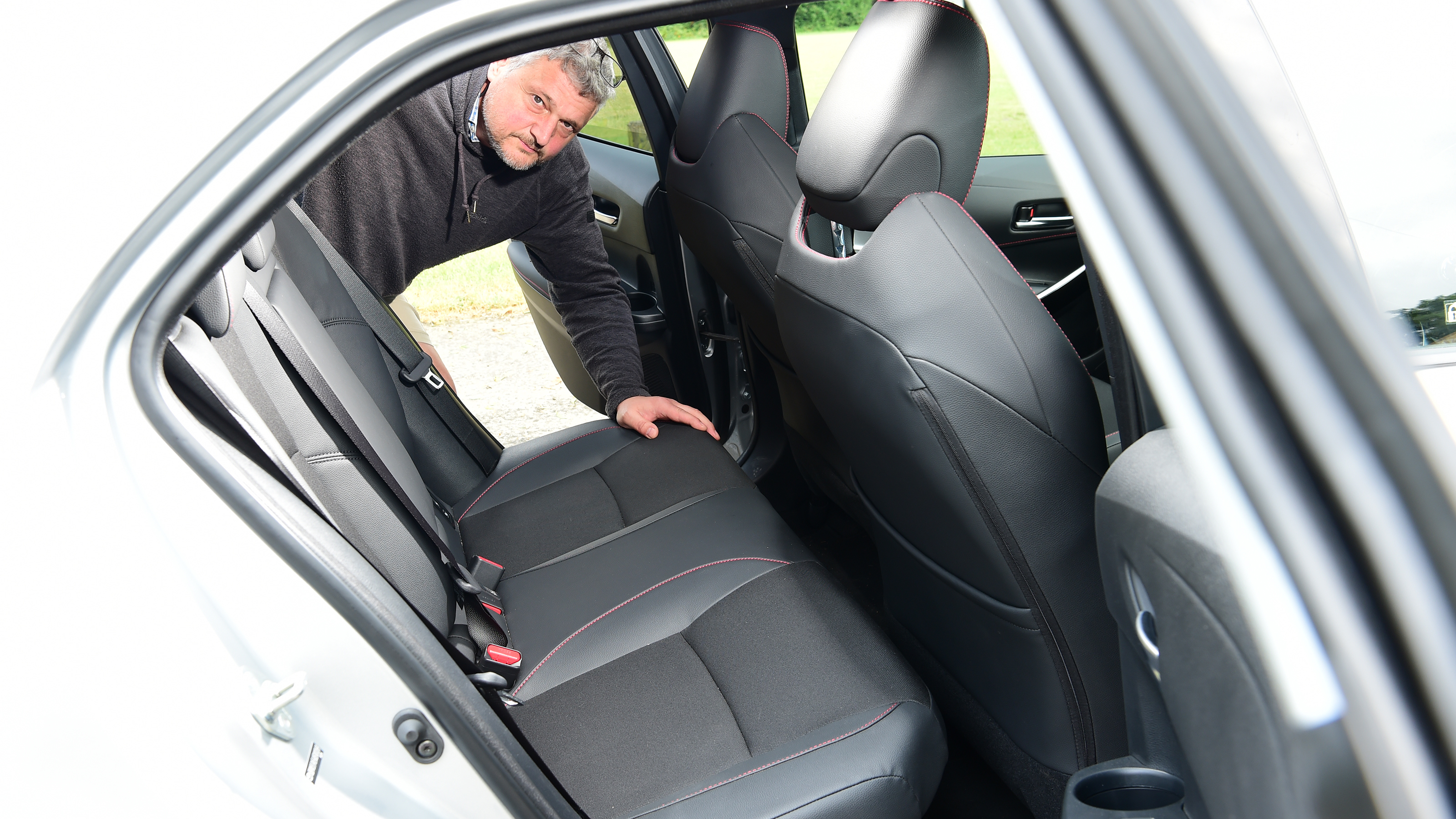 Auto Express current affairs and features editor Chris Rosamond inspecting the Toyota Corolla's back seats