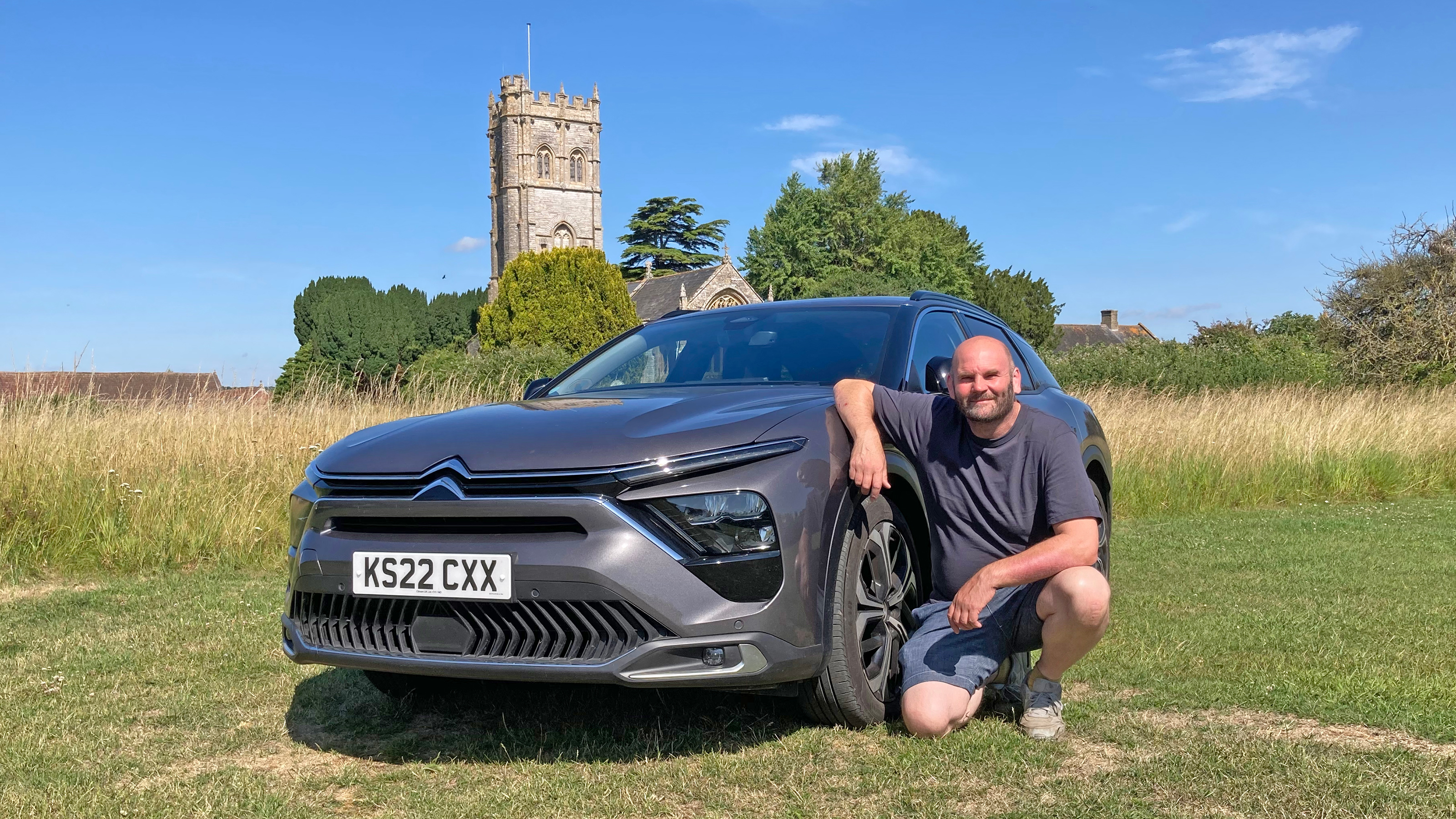 Auto Express creative director Darren Wilson kneeling next to the Citroen C5 X