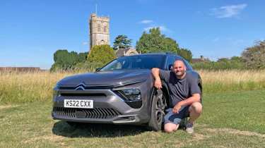 Auto Express creative director Darren Wilson kneeling next to the Citroen C5 X