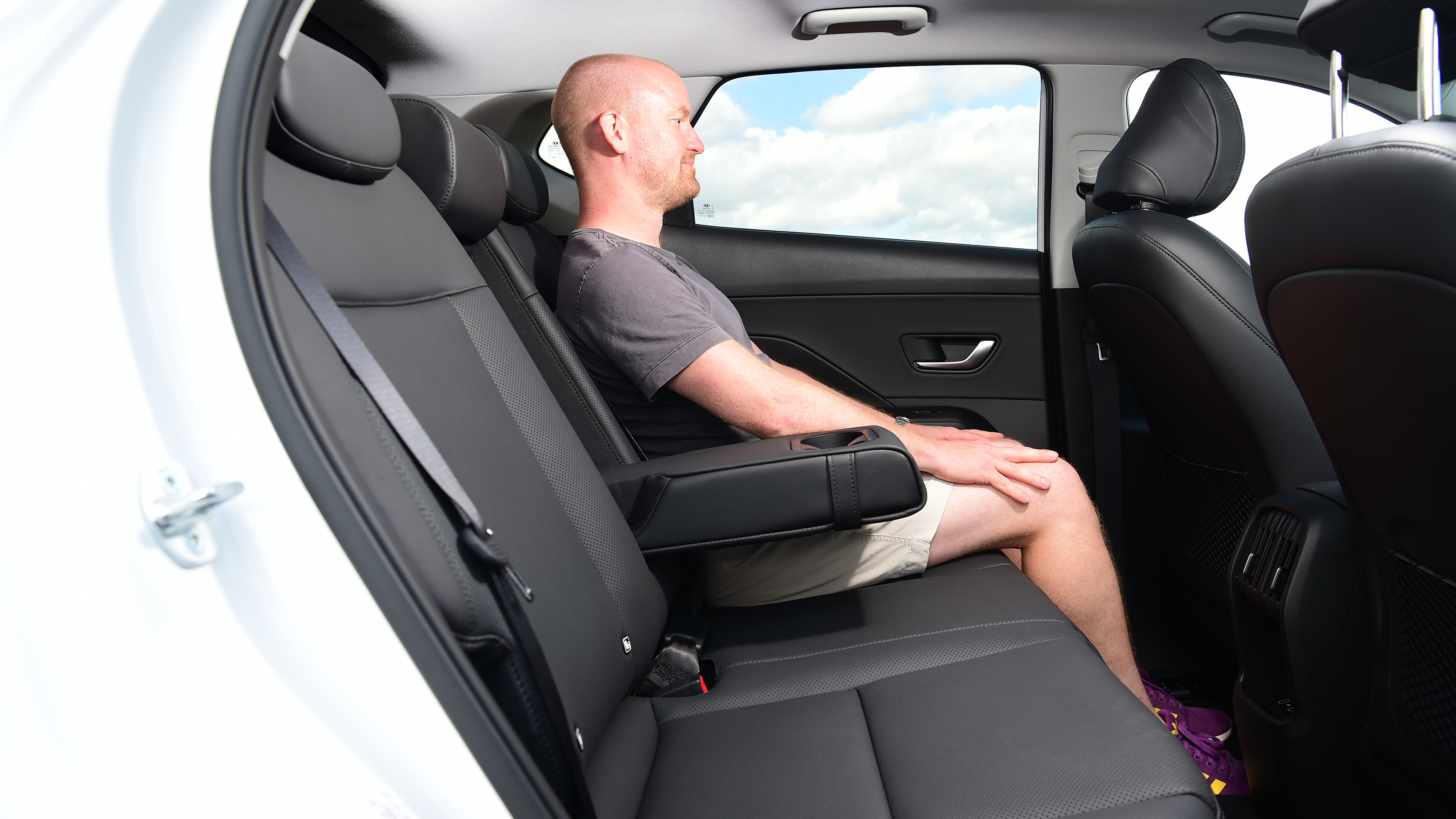 Auto Express chief reviewer Alex Ingram sitting in the back seat of the Hyundai Kona Hybrid