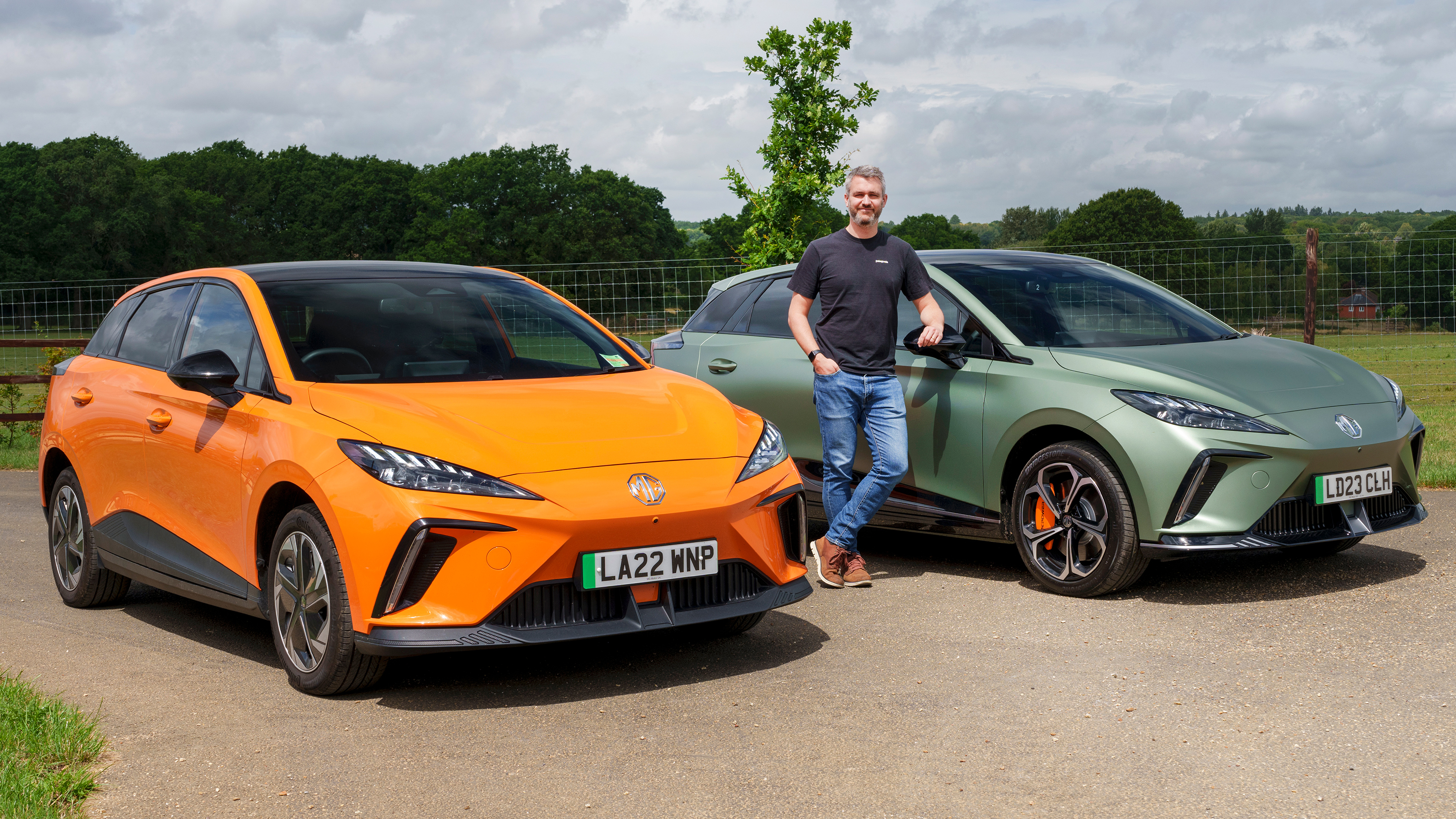 Carbuyer and DrivingElectric editor Richard Ingram standing between the MG4 Trophy and MG4 XPower