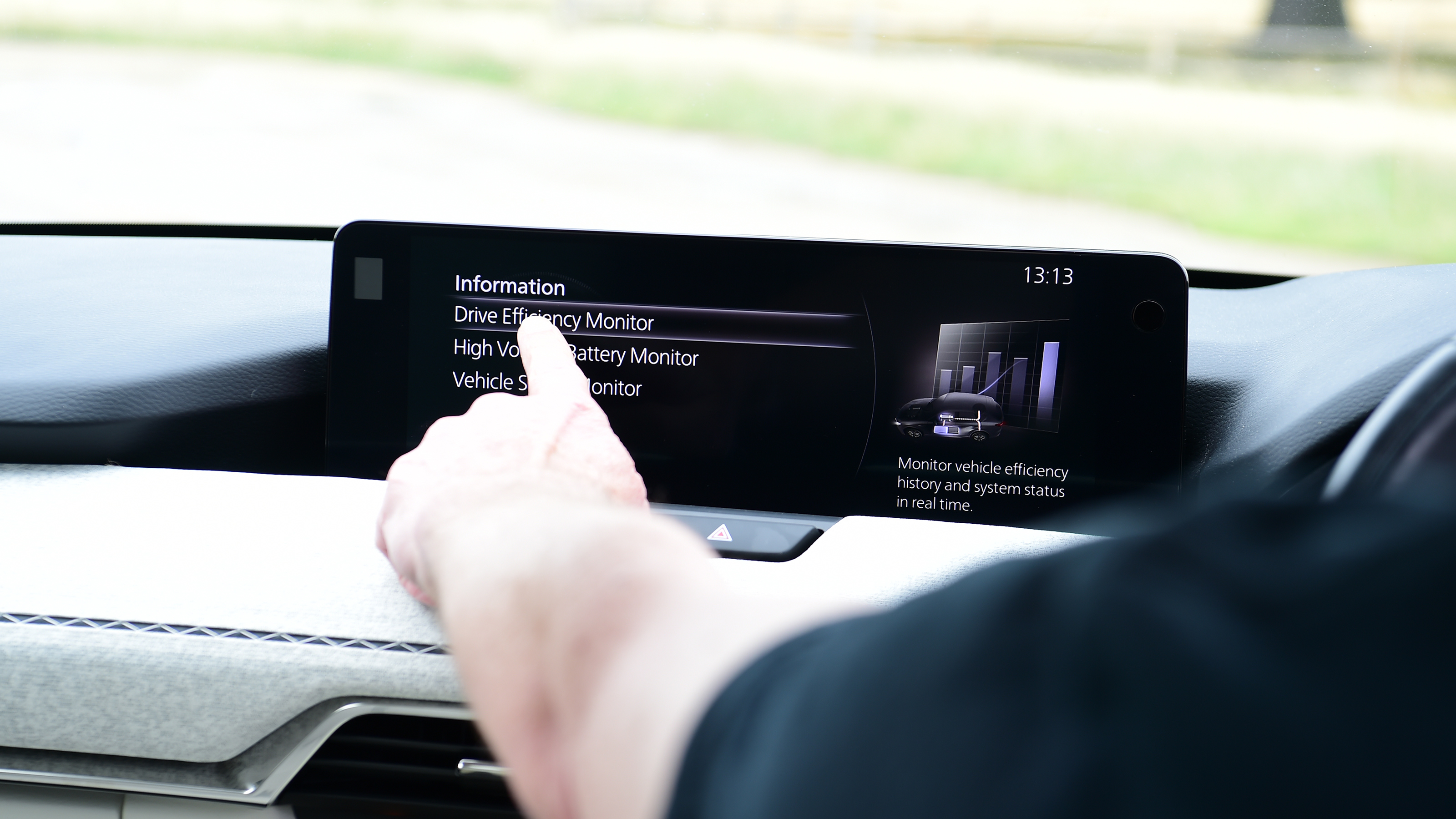 Auto Express chief sub-editor Andy Pringle operating the Mazda CX-60's infotainment system
