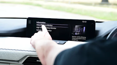 Auto Express chief sub-editor Andy Pringle operating the Mazda CX-60's infotainment system