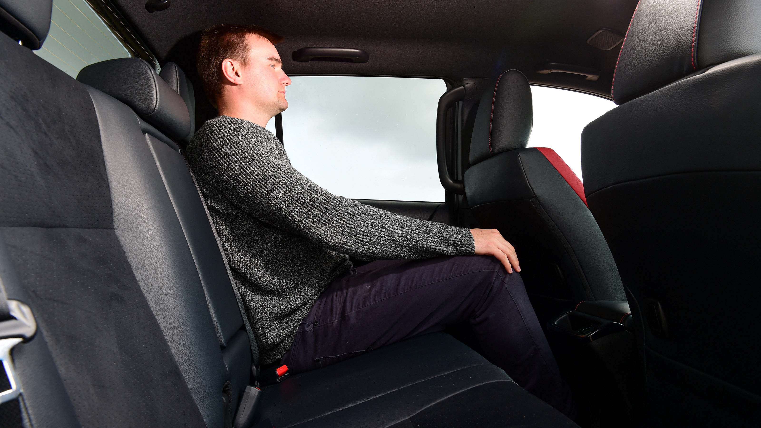 Auto Express staff writer Alastair Crooks sitting in back seat of Toyota Hilux