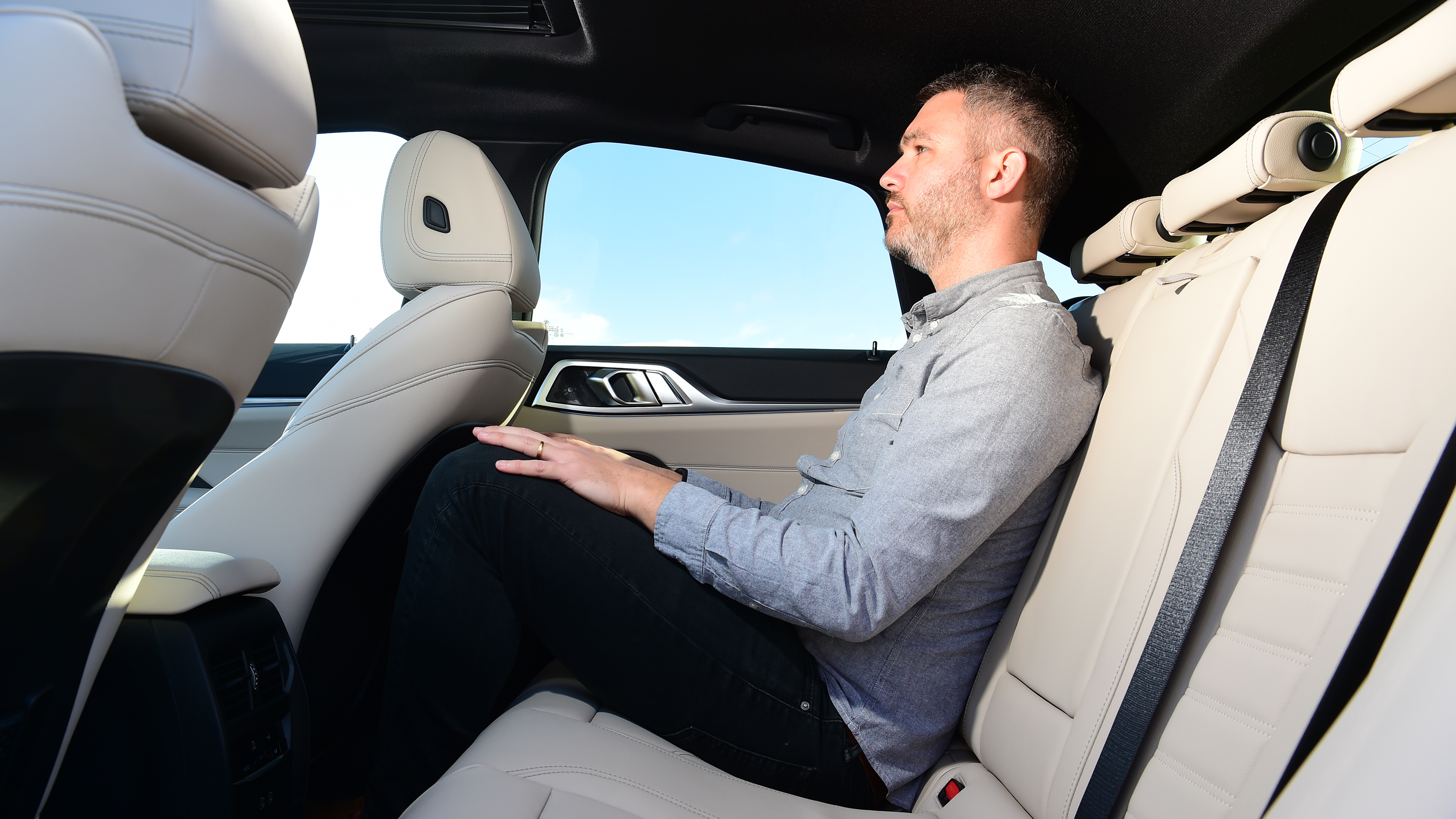Auto Express deputy editor Richard Ingram sitting in the back seat of the BMW i4 eDrive35 M Sport