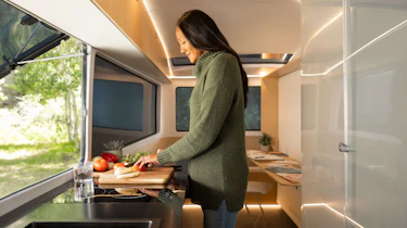 Person using the Pebble Flow caravan's kitchen