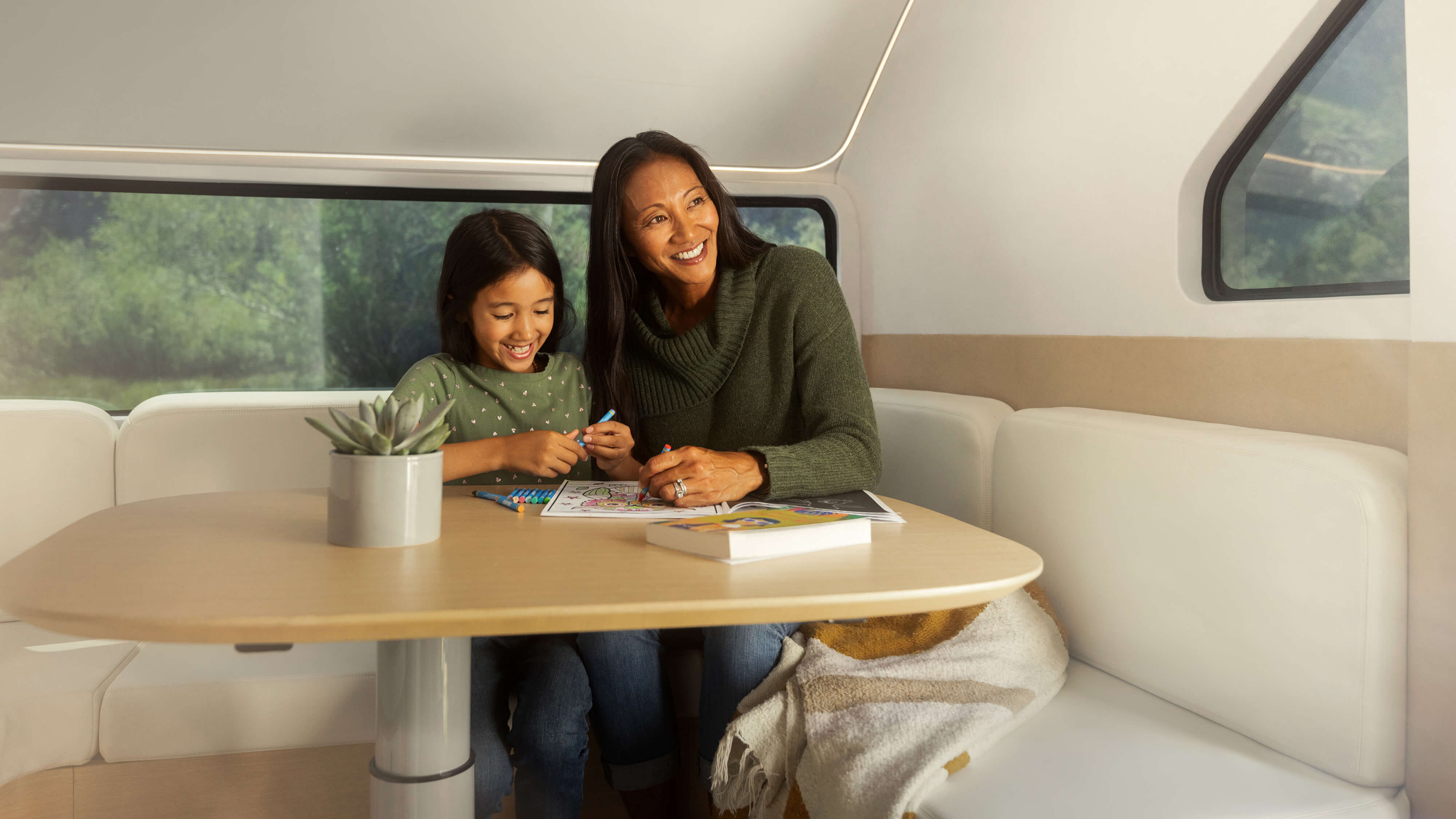 People sitting in the Pebble Flow caravan's lounge area