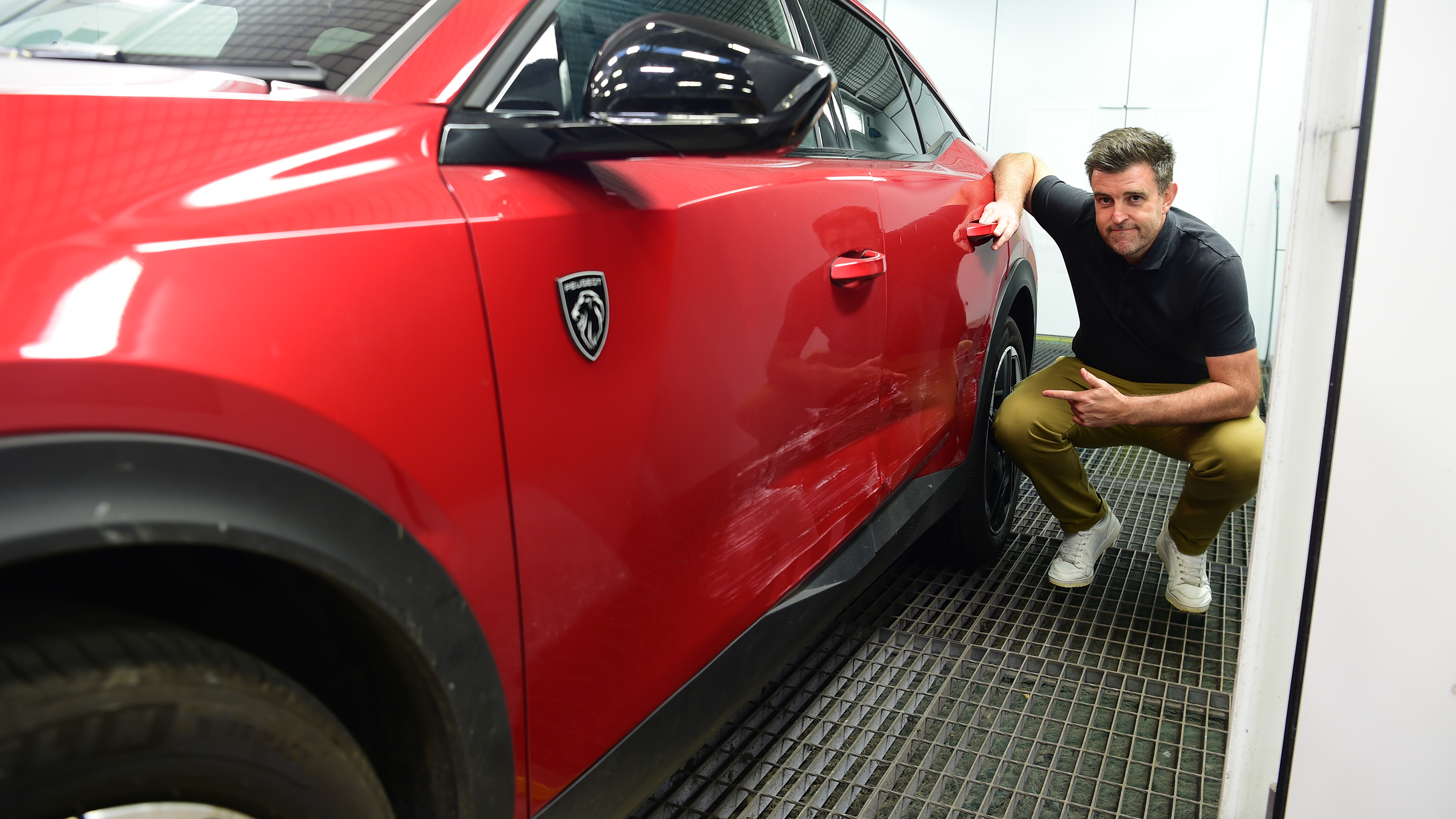 Auto Express head of digital content Steve Walker pointing out the Peugeot 408's damaged doors 