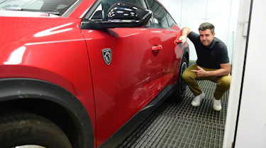 Auto Express head of digital content Steve Walker pointing out the Peugeot 408's damaged doors