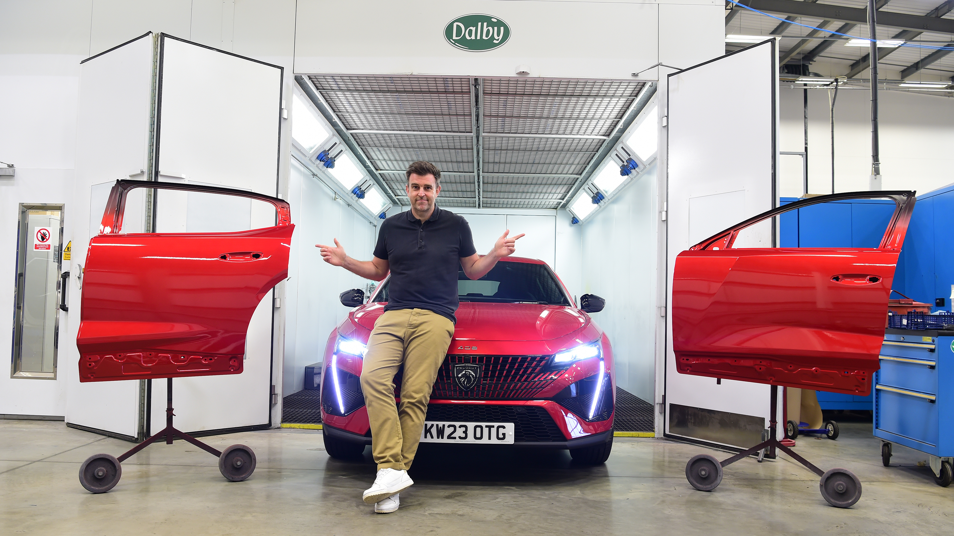 Auto Express head of digital content Steve Walker standing with the Peugeot 408 in a body repair shop
