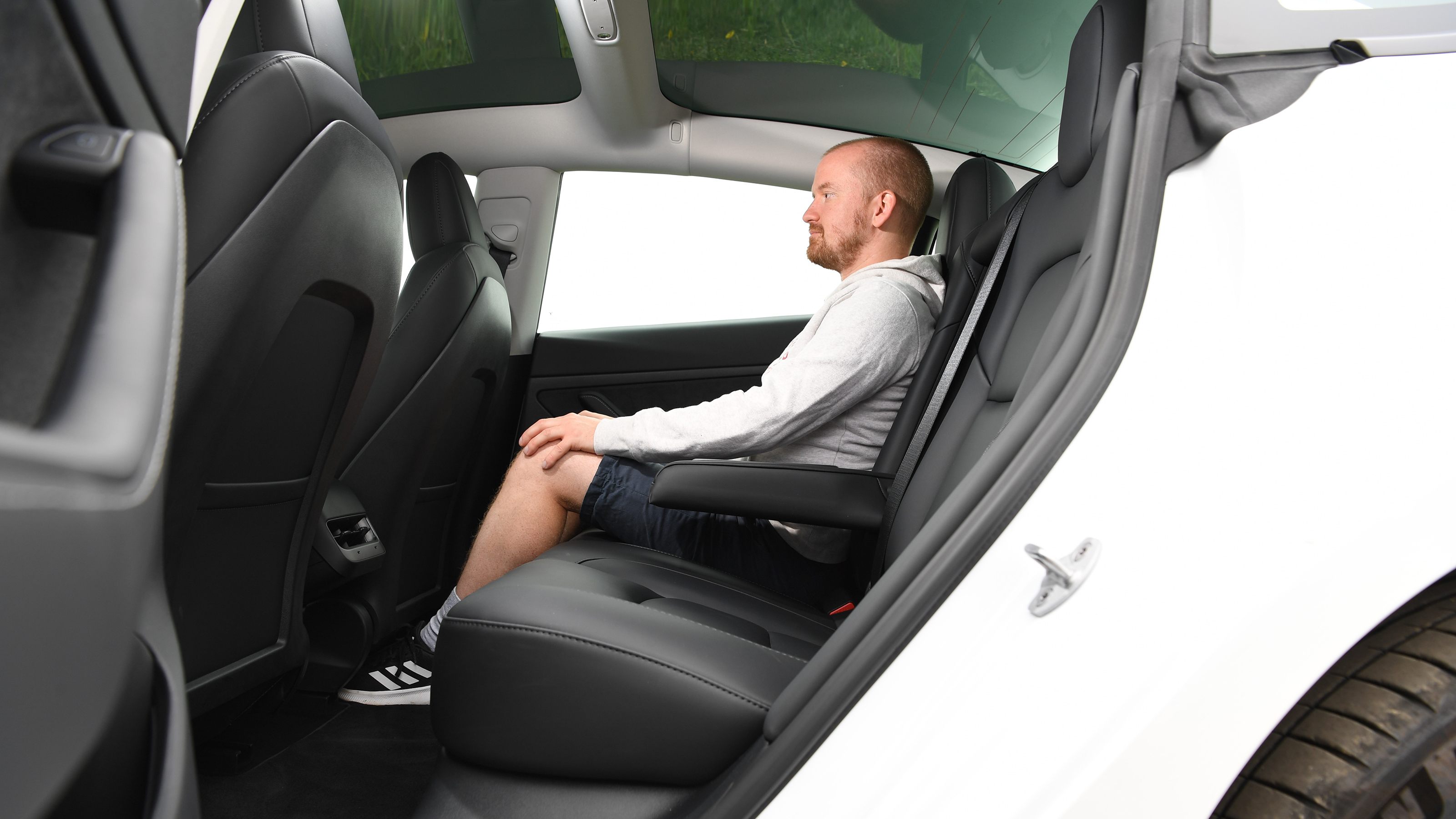 Auto Express chief reviewer Alex Ingram sitting in the Tesla Model 3's rear seats